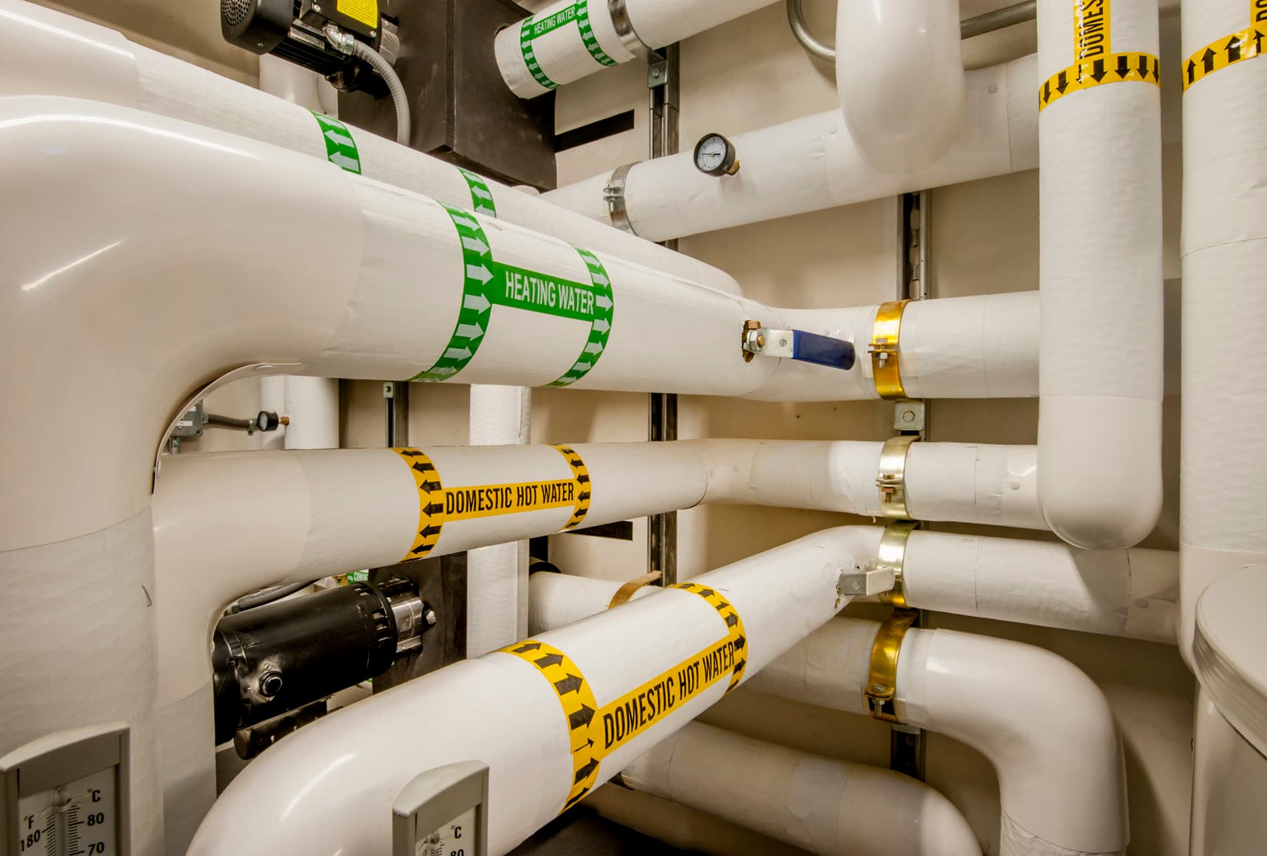 Insulated heating water and domestic hot water piping in a mechanical room